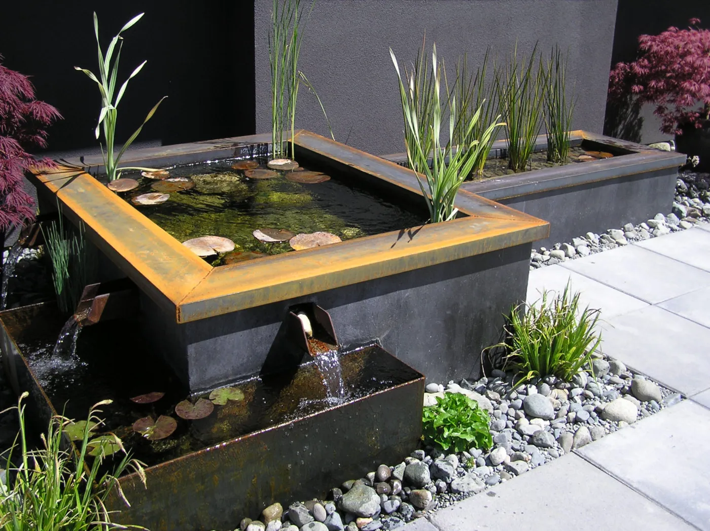 A formal water feature with a clean stone edge set into a Victoria landscape.